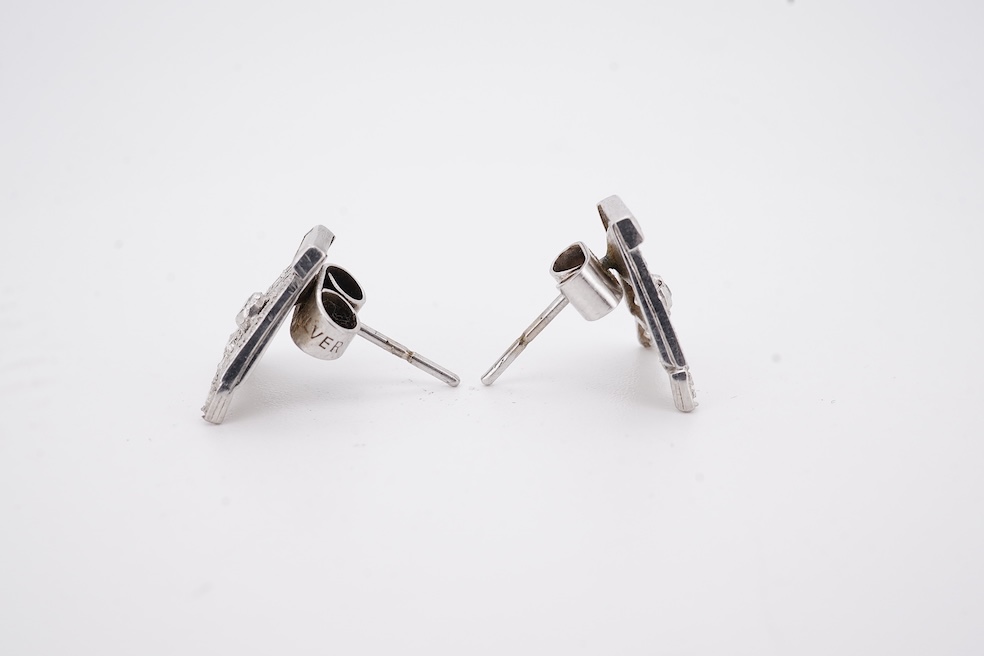 A pair of mid 20th century white metal and millegrain set diamond cluster set 'A' shaped ear studs(adapted from watch lugs?), set with round and baguette cut stones, 12mm, gross weight 3.2 grams.